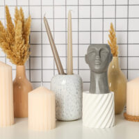 Candles, vases and figurine on light background • Uniqity